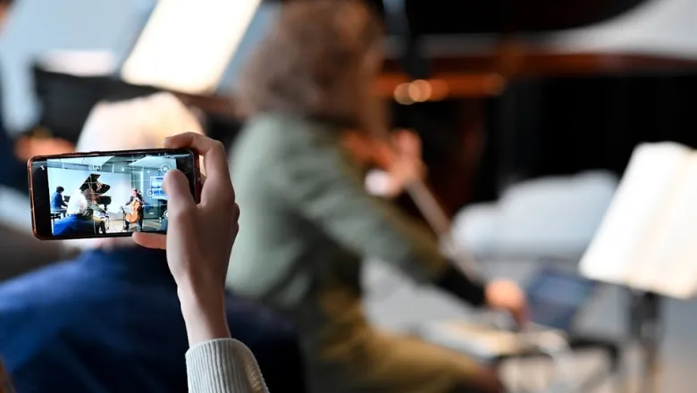 Someone taking a photo of Elaine Chew playing the piano