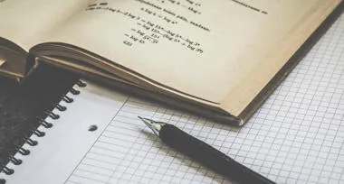 Equations in book, pen and notebook