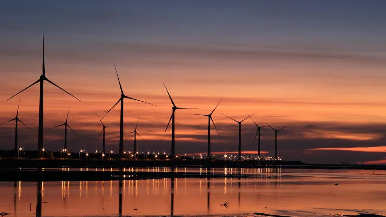 a coastal windfarm in the sunset