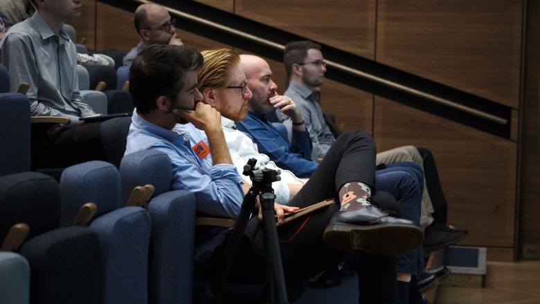FTN Conference Antonio Forte and academics observing stage in chairs