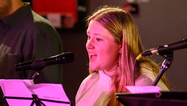 Actor-musician singing on stage