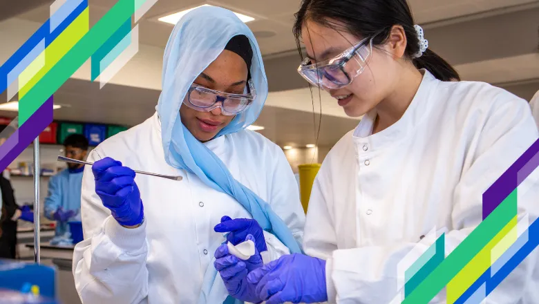 Two girls in lab coats, protective goggles and golves are measuring a chemical ingredient