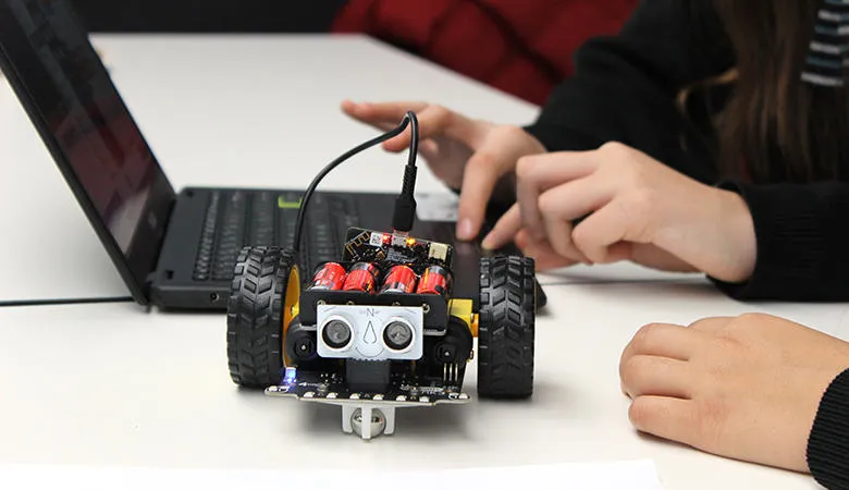 Close-up of a robot next to a laptop
