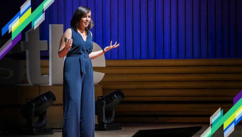 Jen Visser-Rogers standing on a stage talking to an audience