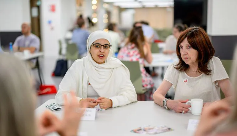 Two female teachers sit at a table talking
