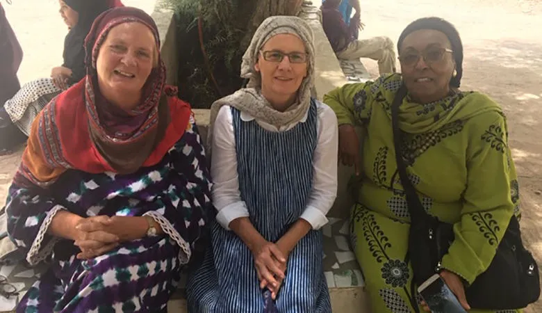 Three women sitting under a tree