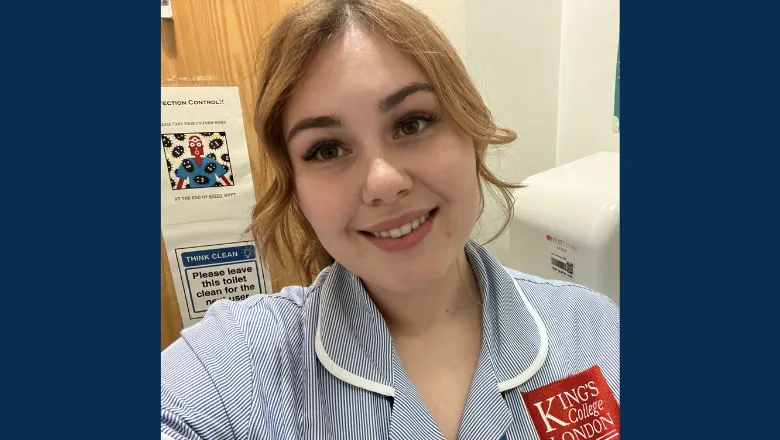 A student midwife in King's training uniform smiles at the camera.