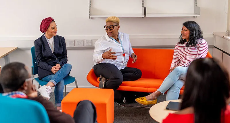 group of students sitting on sofas talking