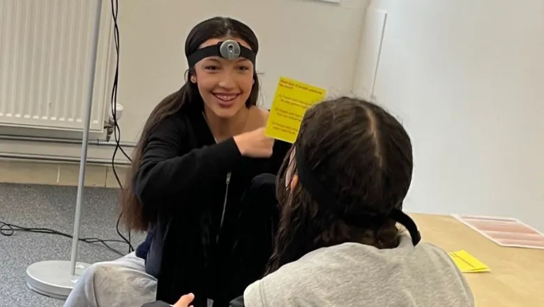 Two teenagers play a game both wearing headcams to study their facial expressions.