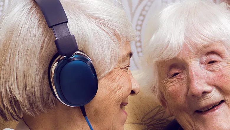 Older people with device and headphones