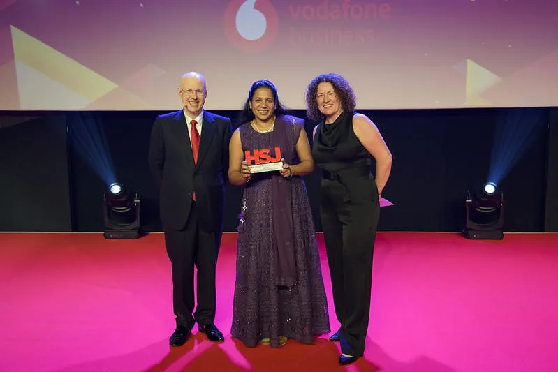 Dr Agimol Pradeep receiving the Health Service Journal award for Workplace Initiative of the Year 2023, with Matt Lucas and Sioban Melia