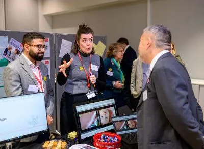 Ragy Tadrous and Honor Morris speaking to a guest