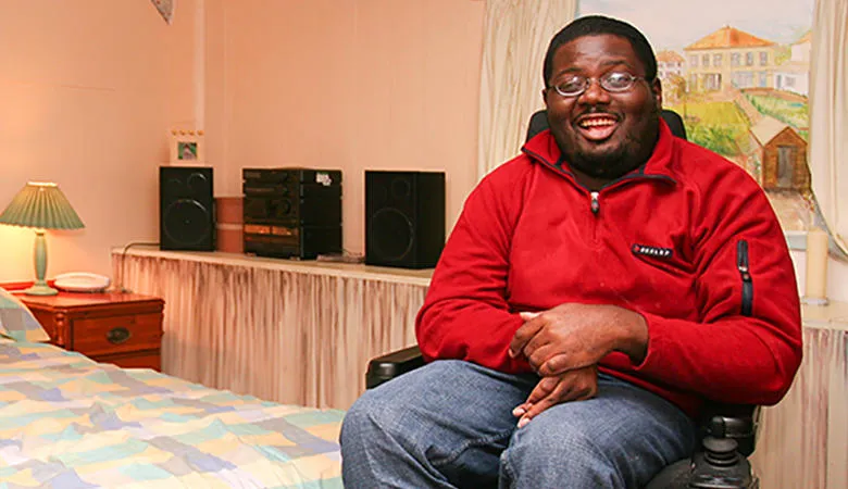 Man in a wheelchair in a bedroom