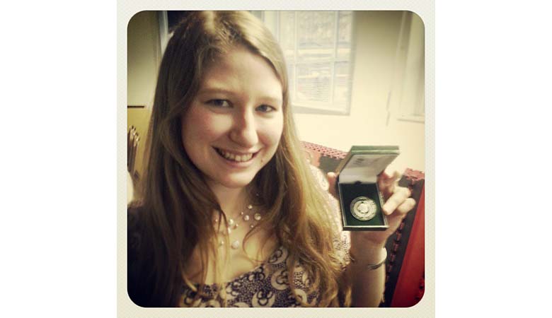 Woman holding a medal in a box