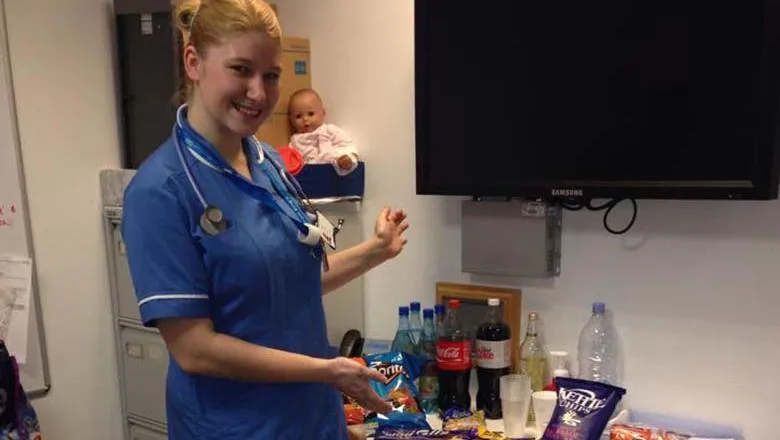 Woman in midwifery uniform standing in front of a table of food