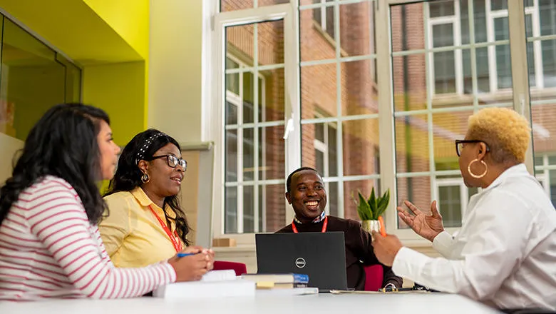 Students sitting at a table in discussion.