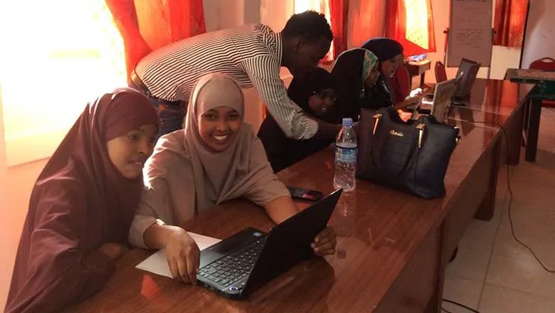 Students in a classroom with a laptop