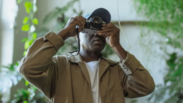 man taking photos with film camera 780 x 440