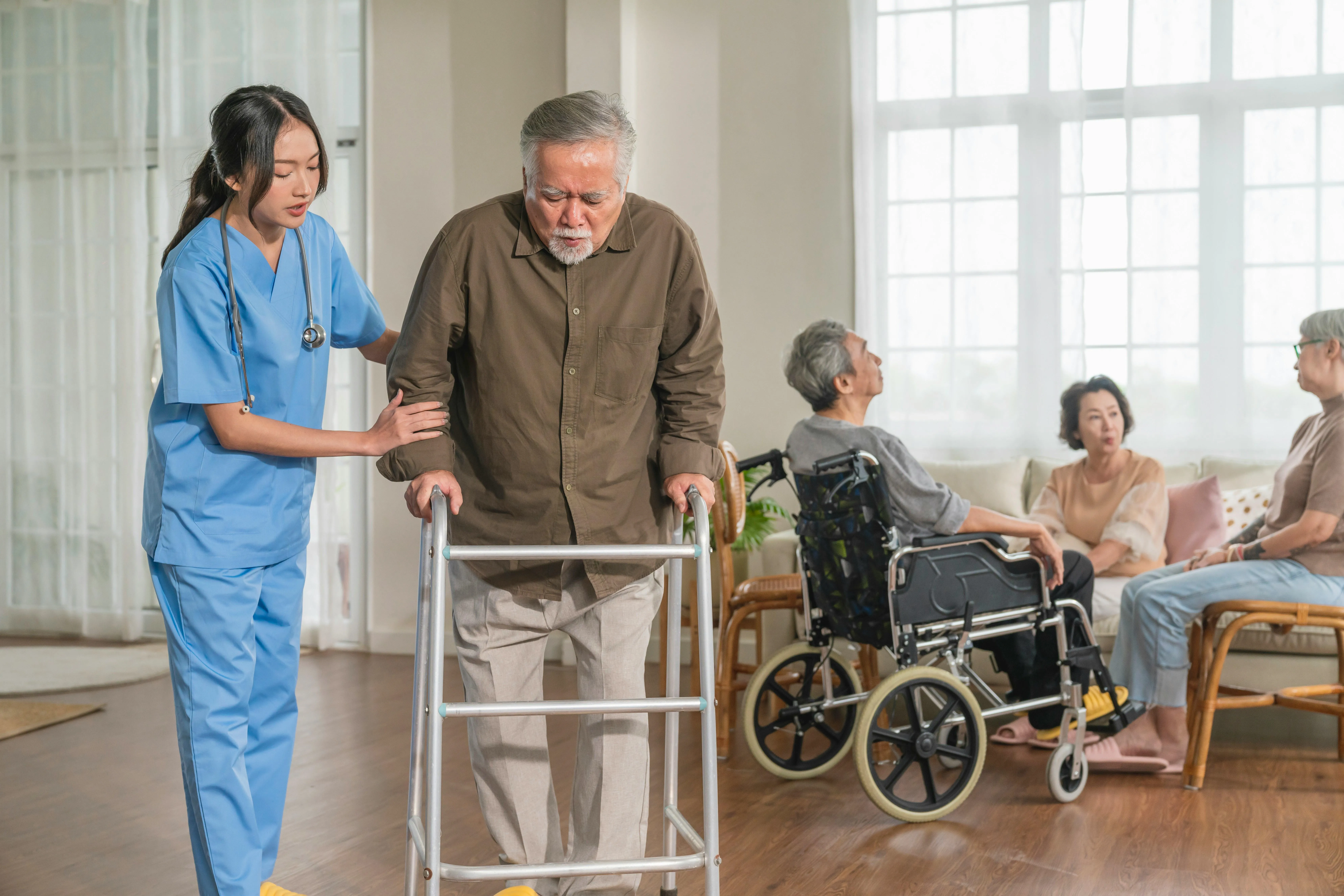 Nurse helping an elderly gentleman walk with a walker