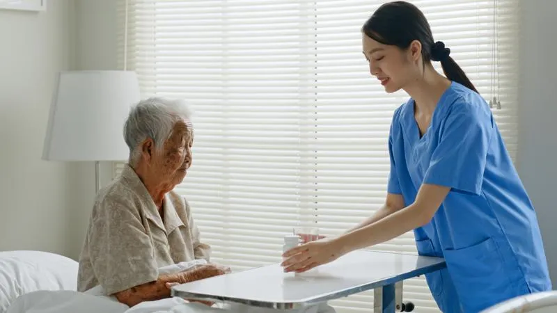 elder person receiving medicine from nurse