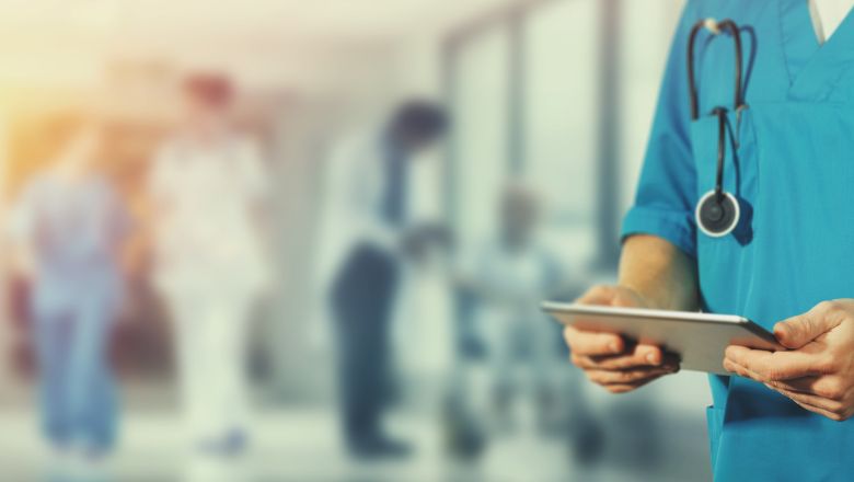 Nurse holding a mobile device in blurry healthcare setting