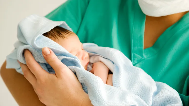 Nurse holding newborn baby