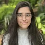 A headshot of Carlota Vazquez Gonzalez. A young woman with long, dark hair wearing glasses. 