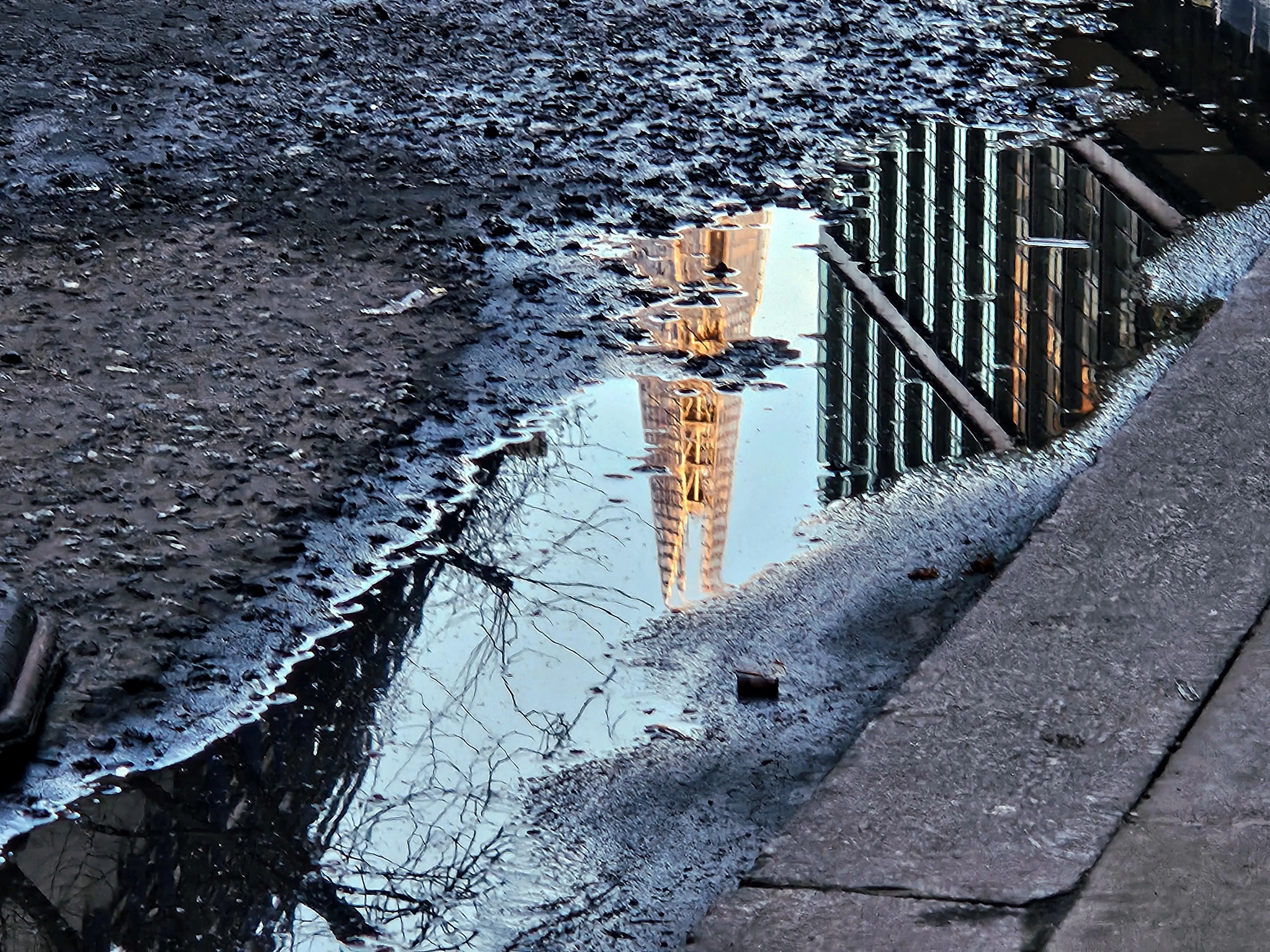Image of a pothole puddle reflecting the Shard