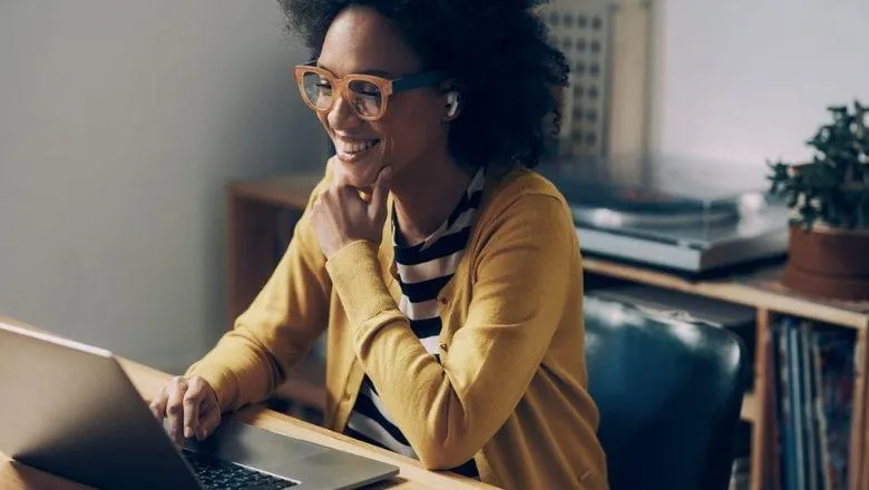 Person smiling and working on laptop