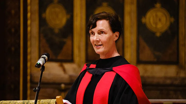 Professor Rachel Mills speaking at a podium in the College Chapel