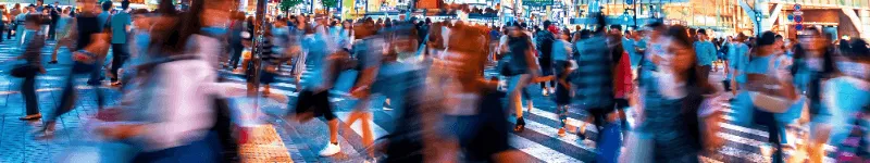 A blurry scene of people at a busy pedestrian crossing.