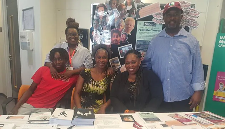 A group of people posing in front of a collection of patient support materials