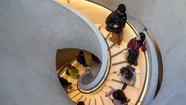 birds-eye view of students walking down spiral staircase