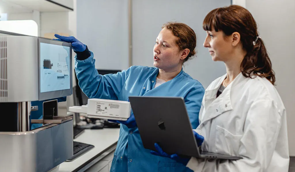 Two scientists looking at lab equipment