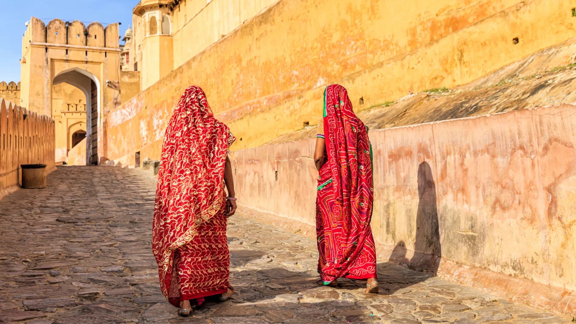Two women walk in a temple, India