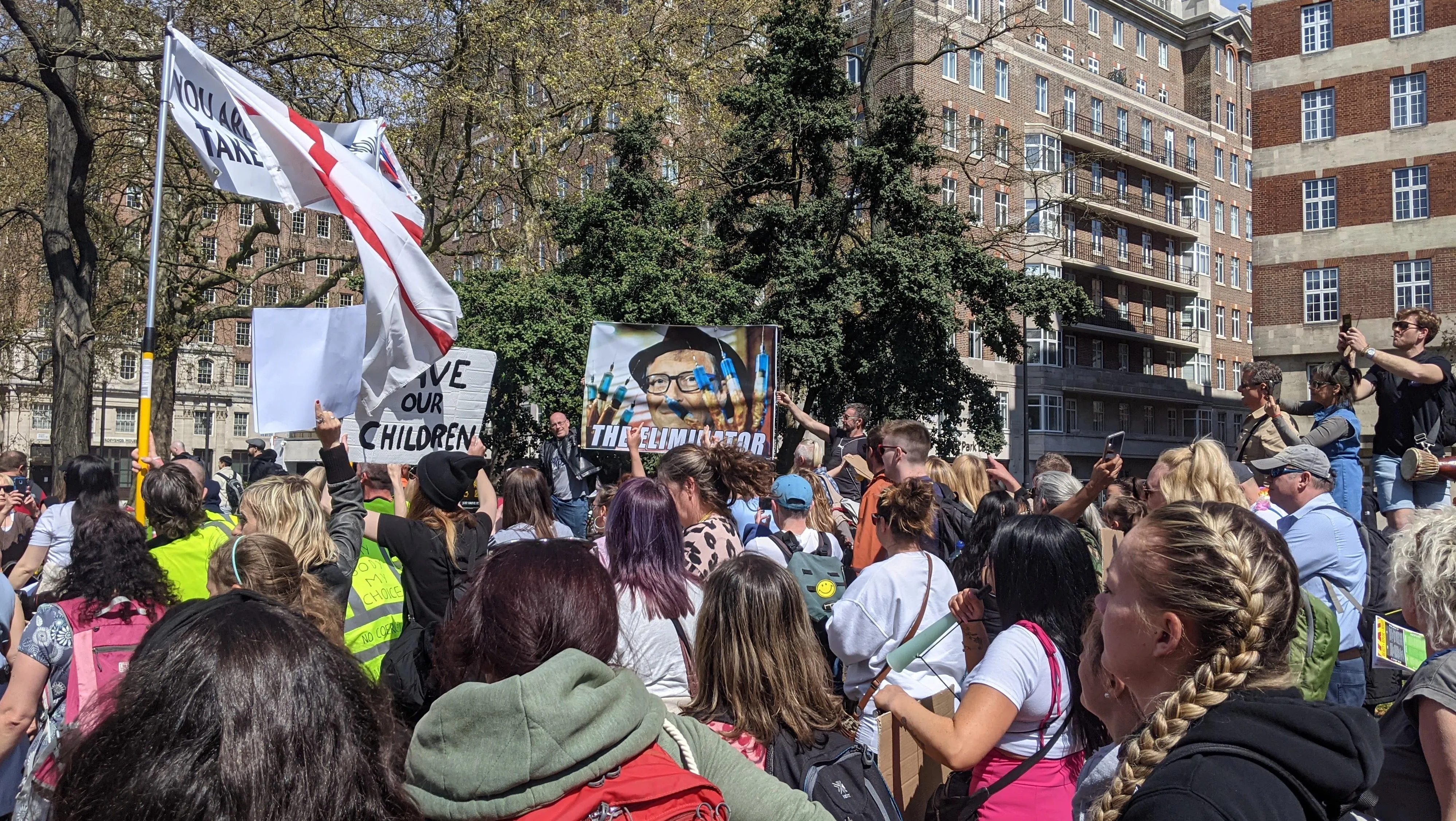 group of protestors march, high-vis jackets, as are flags and placards.