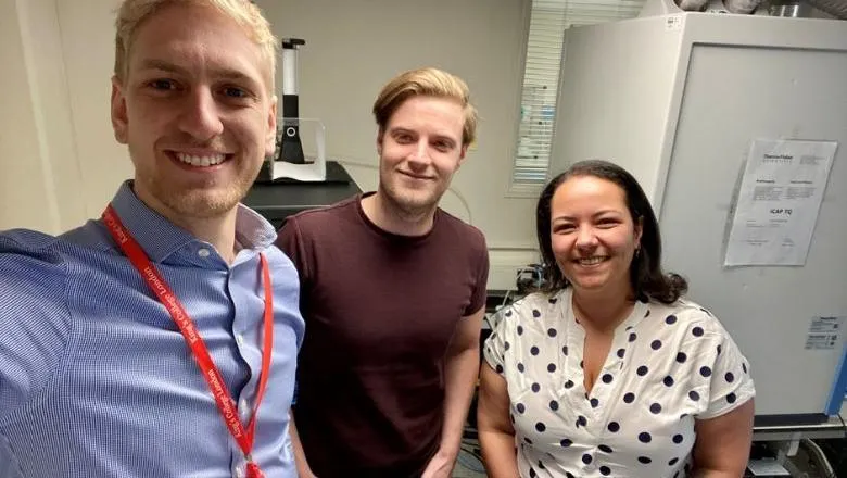 a group of three colleagues in casual business wear pose smiling for a selfie