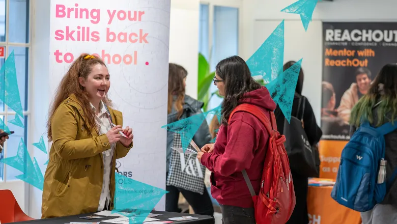 Two people talking at a stall at the King's Volunteering Fair