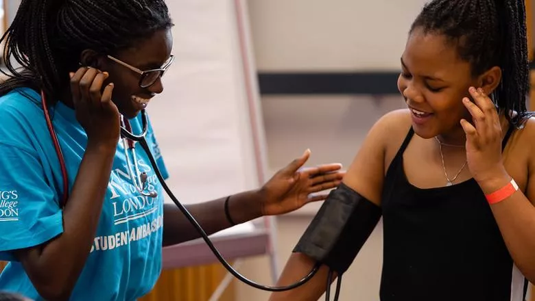 Two female students using a stethoscope