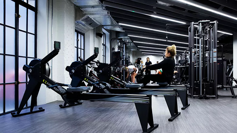 Gym member using rowing machine in Strand Gym.