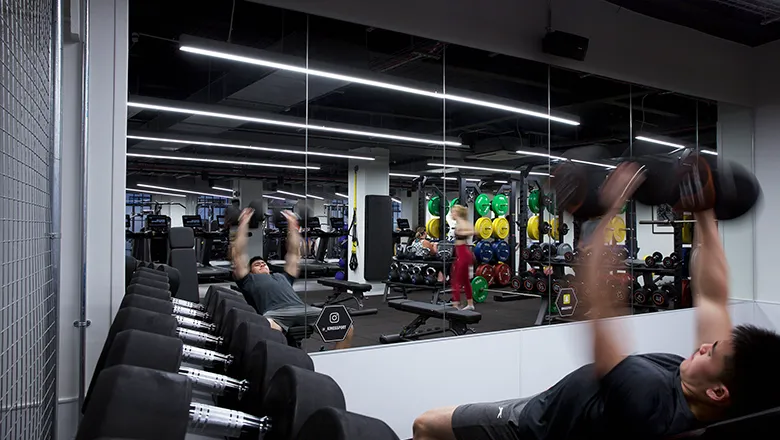 Gym member lifting weights in Strand Gym. 