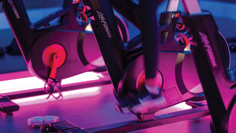 individual peddling on spin bike