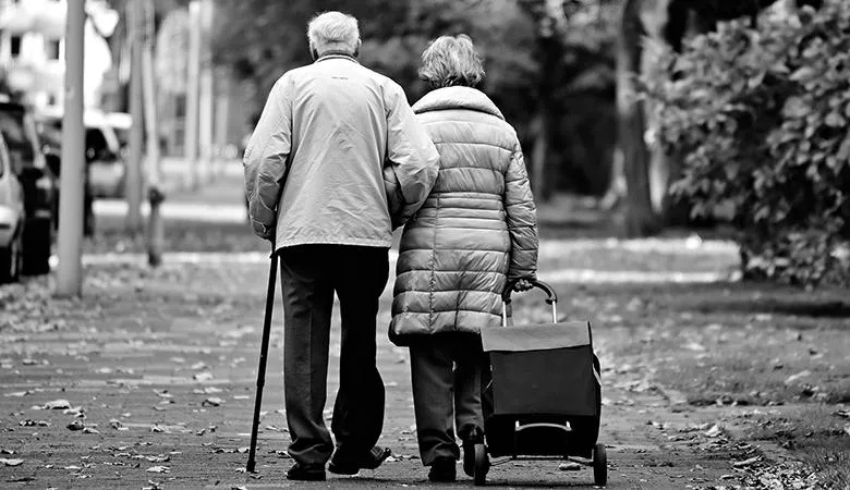 An elderly couple arm in arm