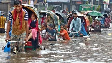 Vehicles try to drive through a flooded street in Dhaka, Bangladesh