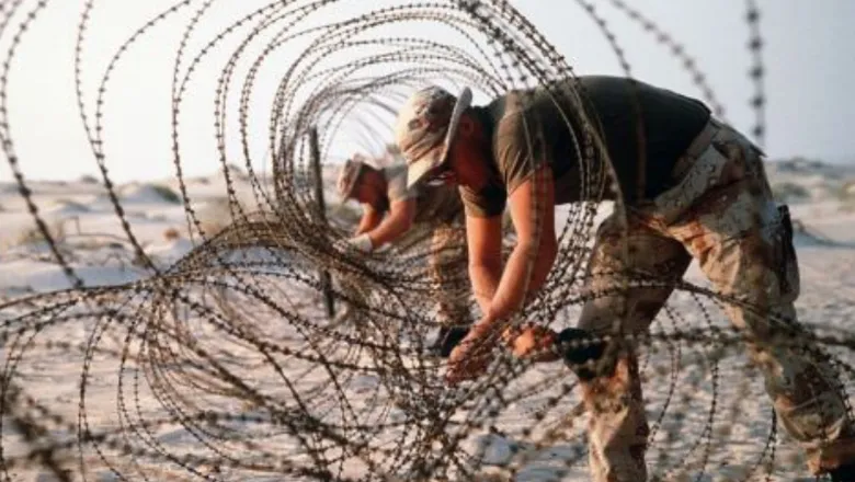 Soldiers rolling barbed wire