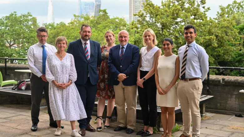 The Freeman Air and Space Institute team smile for a group photograph in front of the London skyline.