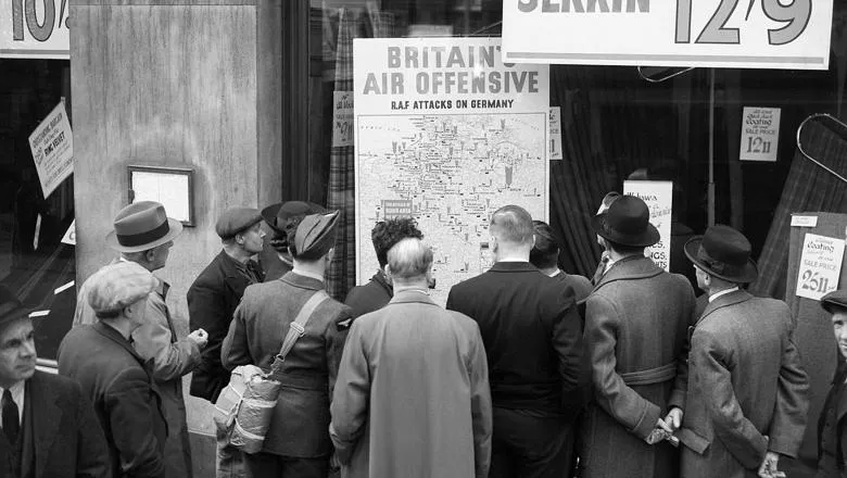 Londoners in 1940 look at a map illustrating how the RAF is striking back. 