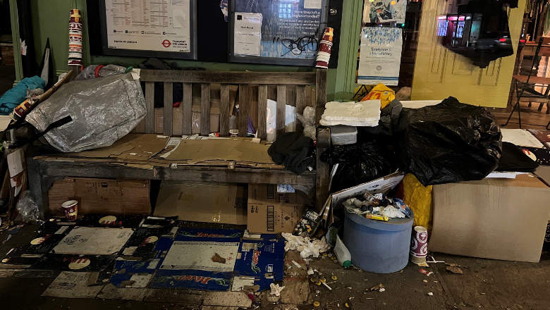 A bench with a person's belongings on and about it