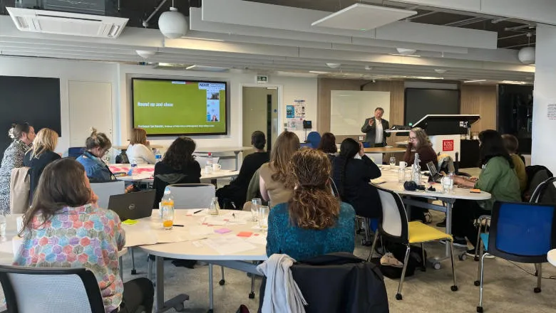 People sitting at tables listening to a presentation