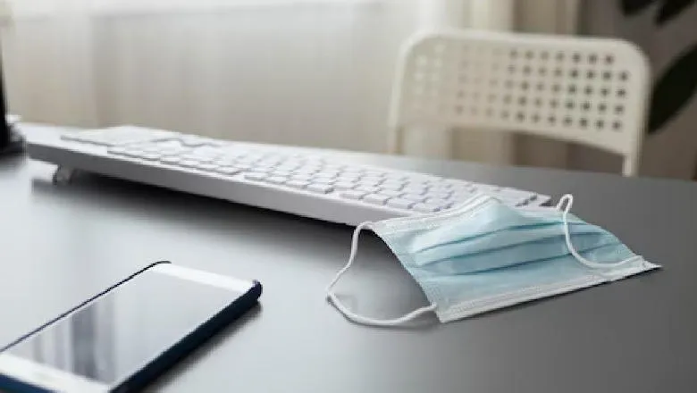 Computer keyboard, mask and mobile phone on table